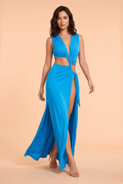 Robe longue bleue à encolure asymétrique, découpes à la taille et détails dorés | Vue en mouvement | Lounelle Paris