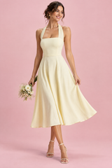 Light yellow sleeveless skater midi dress with a halter neckline